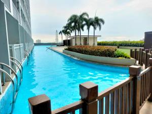 een zwembad in het midden van een gebouw met palmbomen bij Smdc Breeze Residence in Manilla
