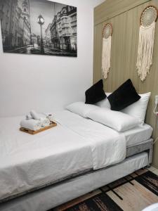 een slaapkamer met een bed met witte lakens en zwarte kussens bij Smdc Breeze Residence in Manilla