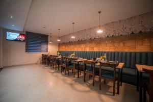 comedor con mesas y sillas y TV en Zip By Spree Hotels Gangtok en Gangtok