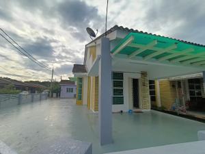 ein Gebäude mit einem Dach mit einer Pergola in der Unterkunft HOMESTAY BERTAM SAFAR in Kepala Batas