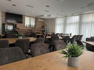 a conference room with wooden tables and chairs at Pansion Komfor Fitea in Osijek