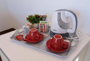 a table with two red cups and a coffee maker at Gran Sasso Letizia BB in Filetto