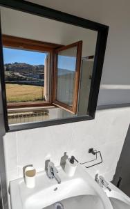 W łazience znajduje się umywalka z lustrem i okno. w obiekcie Gran Sasso Letizia BB w mieście Filetto