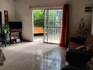a living room with a christmas tree and a sliding glass door at Casa Roma 3 Parque a 3 del solis in Parque del Plata