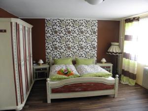 una camera con un letto con una parete floreale di Hotel 4 Jahreszeiten mit Restaurant ad Albstadt