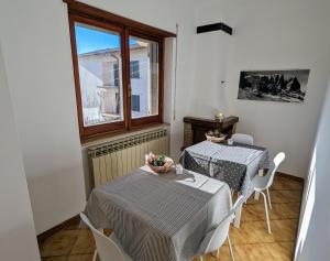 a dining room with two tables and a window at Gran Sasso Letizia BB in Filetto
