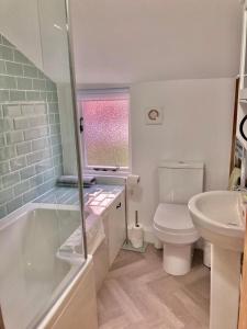 uma casa de banho com uma banheira, um WC e um lavatório. em Almond Cottage Clare - 2 bedroom English Cottage em Clare