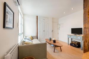 ein Wohnzimmer mit einem Sofa und einem Tisch in der Unterkunft 1 bedroom 1 bathroom furnished - Malasaña - Modern in downtown area - MintyStay in Madrid