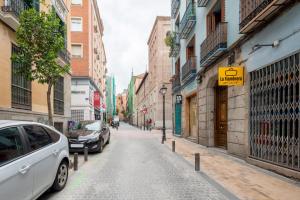 eine Stadtstraße mit auf der Straße geparkt in der Unterkunft 1 bedroom 1 bathroom furnished - Malasaña - Modern in downtown area - MintyStay in Madrid