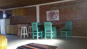 une cuisine avec des chaises vertes, une table et un mur en briques dans l'établissement Monoambiente Luminoso (permitido mascotas), à Camet Norte
