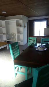 une salle à manger avec une table et des chaises vertes dans l'établissement Monoambiente Luminoso (permitido mascotas), à Camet Norte