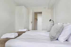 a large white bed with white sheets and pillows at Guestly Homes - 1BR Corporate Comfort in Boden