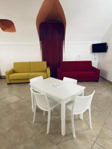 a white table and chairs in a room with a couch at Napoli Apartment in Naples