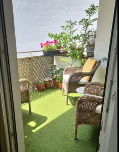 a balcony with chairs and potted plants on it at Rooms in Luxury Apartment, Central Vienna near Hauptbahnhof in Vienna
