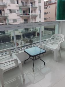 a balcony with two chairs and a table on a building at Apto Guaruja Astúrias in Guarujá