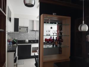 a kitchen with a shelf with wine glasses at Apto Guaruja Astúrias in Guarujá