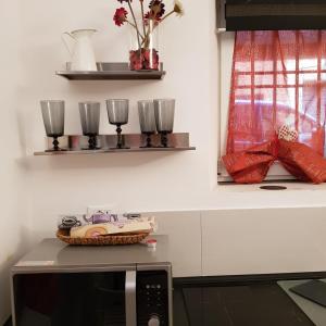 a kitchen with a counter with glasses and a table at Affection Apartment in Bologna