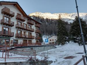 un hotel en las montañas con nieve en el suelo en Trilocale BELVEDERE Alloggio ad uso turistico - VDA - LA THUILE - CIR 0068, en La Thuile