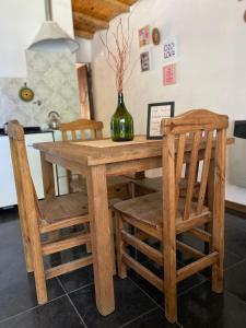 una mesa de madera con 2 sillas y un jarrón. en San Julián en San Rafael