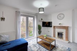 a living room with a blue couch and a fireplace at 20% Off 4 Bed Home with Driveway and Garden in Preston