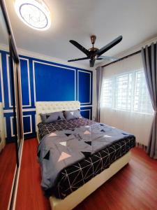 a blue bedroom with a bed and a ceiling fan at QM Homestay in Semenyih