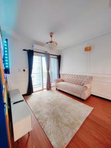 ein Wohnzimmer mit einem Sofa und einem großen Fenster in der Unterkunft QM Homestay in Semenyih