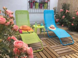 two chairs and a table on a patio with flowers at Oak House Oakplacescom in León