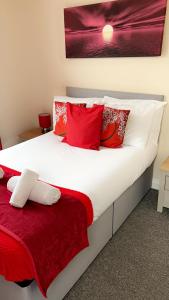 a bedroom with a large bed with red pillows at Nick's Place in Plymouth