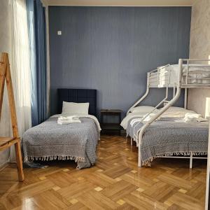 1 dormitorio con 2 literas y suelo de madera en Memory basket en Kutaisi