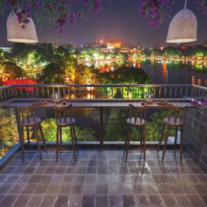 a balcony with a view of the city at night at La Belle Maison in Hanoi