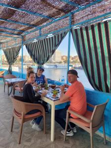 um grupo de pessoas sentadas à mesa a comer em Jamaica Guest House em Aswan