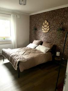 a bedroom with a large bed with a brick wall at Ferienhaus Pinieneck in Bad Laasphe