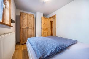 1 dormitorio con 1 cama y puertas de madera. en Fewo mit Behelfsküche in Heckenbeck, en Bad Gandersheim