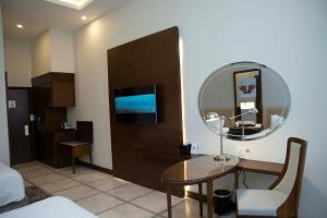 a living room with a table and a mirror at Pearl Continental Hotel, Bhurban in Bhurban