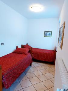 1 dormitorio con 2 camas con sábanas rojas en Trilocale BELVEDERE Alloggio ad uso turistico - VDA - LA THUILE - CIR 0068, en La Thuile