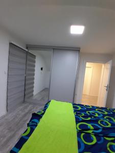 ein Schlafzimmer mit einem Bett, auf dem eine grüne Decke liegt in der Unterkunft Inalux Apartmani Pale in Gornje Pale
