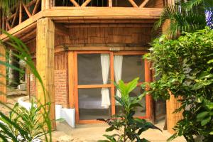 uma pequena casa de madeira com uma janela num jardim em Hierba Buena Eco Hostel em El Zaino