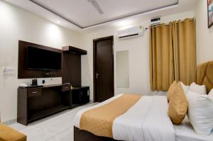 a hotel room with a bed and a flat screen tv at Hotel DHD - PAHARGANJ in New Delhi