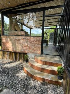 eine Terrasse mit Treppe und Ziegelwand in der Unterkunft Casa Container, Vista para o Lago e integrada com a Natureza - Miguel Pereira in Miguel Pereira
