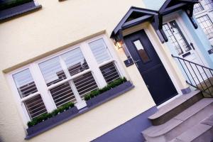 a house with a black door and a window at Georges Bank in The Mumbles