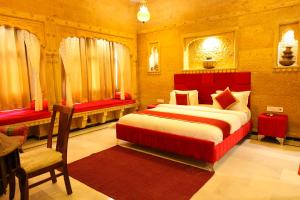 a bedroom with a large bed and a red headboard at Garh Meera - A Sensational Boutique Hotel in Jaisalmer