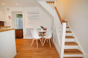 a dining room with a table and white chairs at Georges Bank in The Mumbles