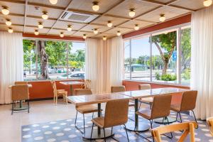 a conference room with tables and chairs and windows at B&B HOTEL Santos Dumont in Rio de Janeiro