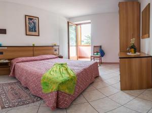 a bedroom with a bed with a red comforter at Residence Betulla Molveno in Molveno