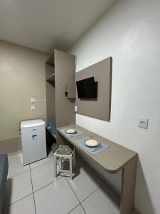 a bathroom with a counter with two sinks and a tv at Villa Germânia - Pousada da Luiza in Santa Cruz do Sul