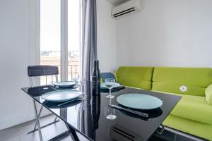 - un salon avec un canapé vert et une table dans l'établissement Top Floor Terrace - Dernier Etage Terrasse Cosy, à Nice