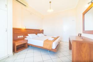 a bedroom with a bed and a desk and a sink at Lido Sofia Apartments in Agios Gordios