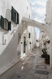 an alley with white buildings and an archway at Cà Giò in Ostuni