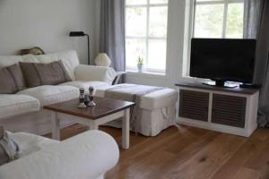 a living room with white furniture and a flat screen tv at Ferienhaus" Blaubeer" in Michaelsdorf in Michaelsdorf