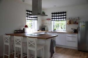 a kitchen with a refrigerator and a counter with stools at Ferienhaus" Blaubeer" in Michaelsdorf in Michaelsdorf